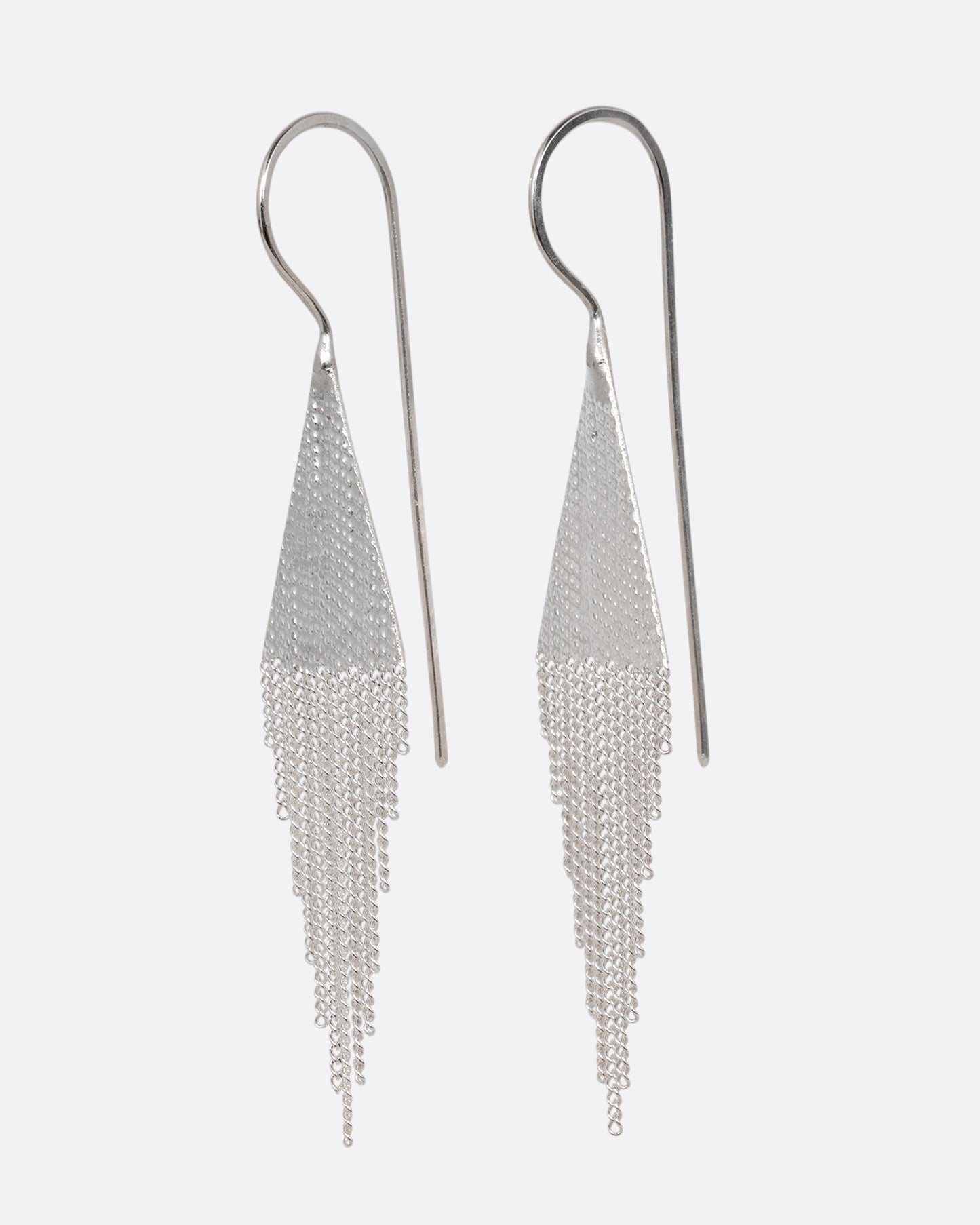 A pair of silver drop earrings with triangular tops and cable chain fringe bottoms. Shown from the side.