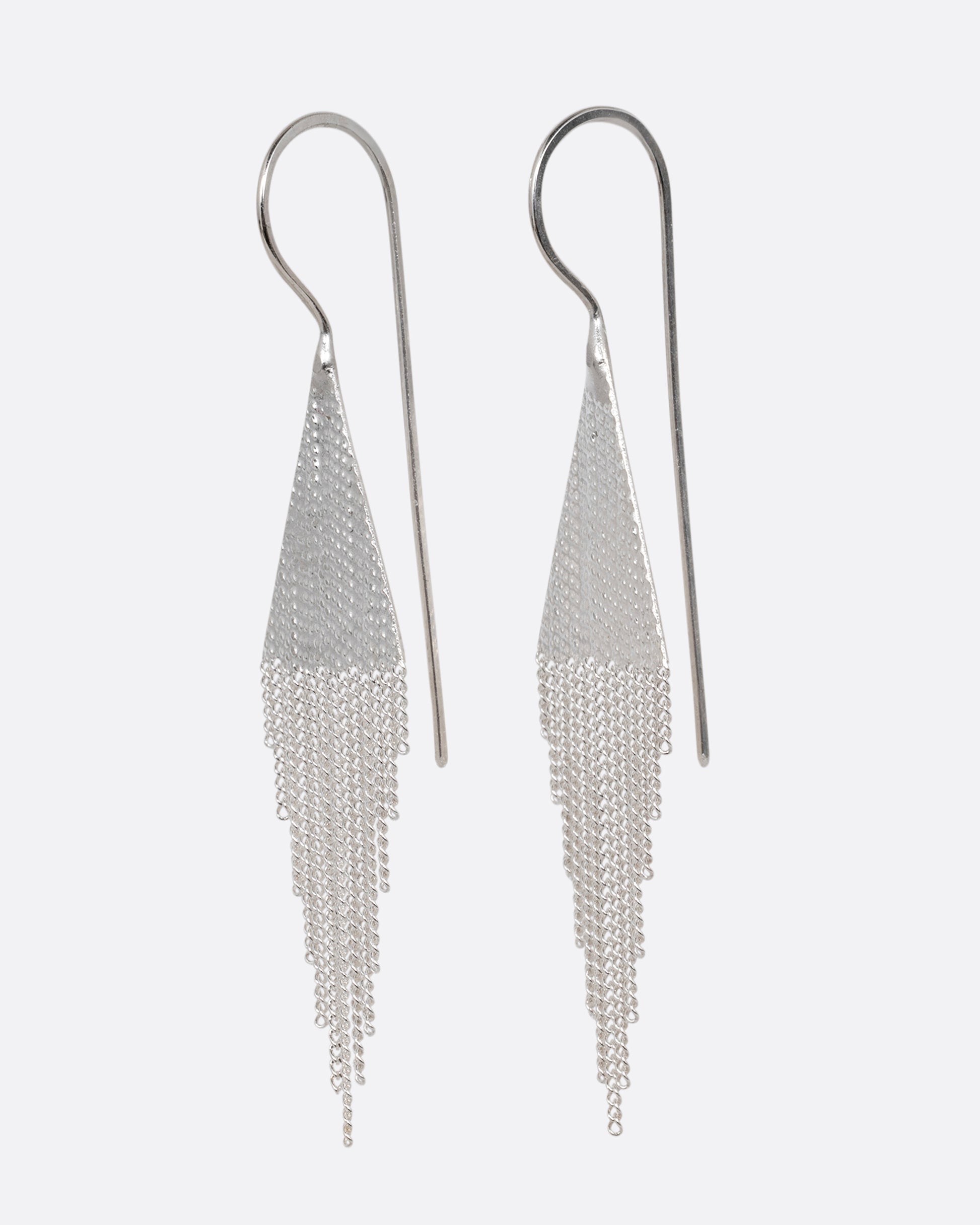 A pair of silver drop earrings with triangular tops and cable chain fringe bottoms. Shown from the side.