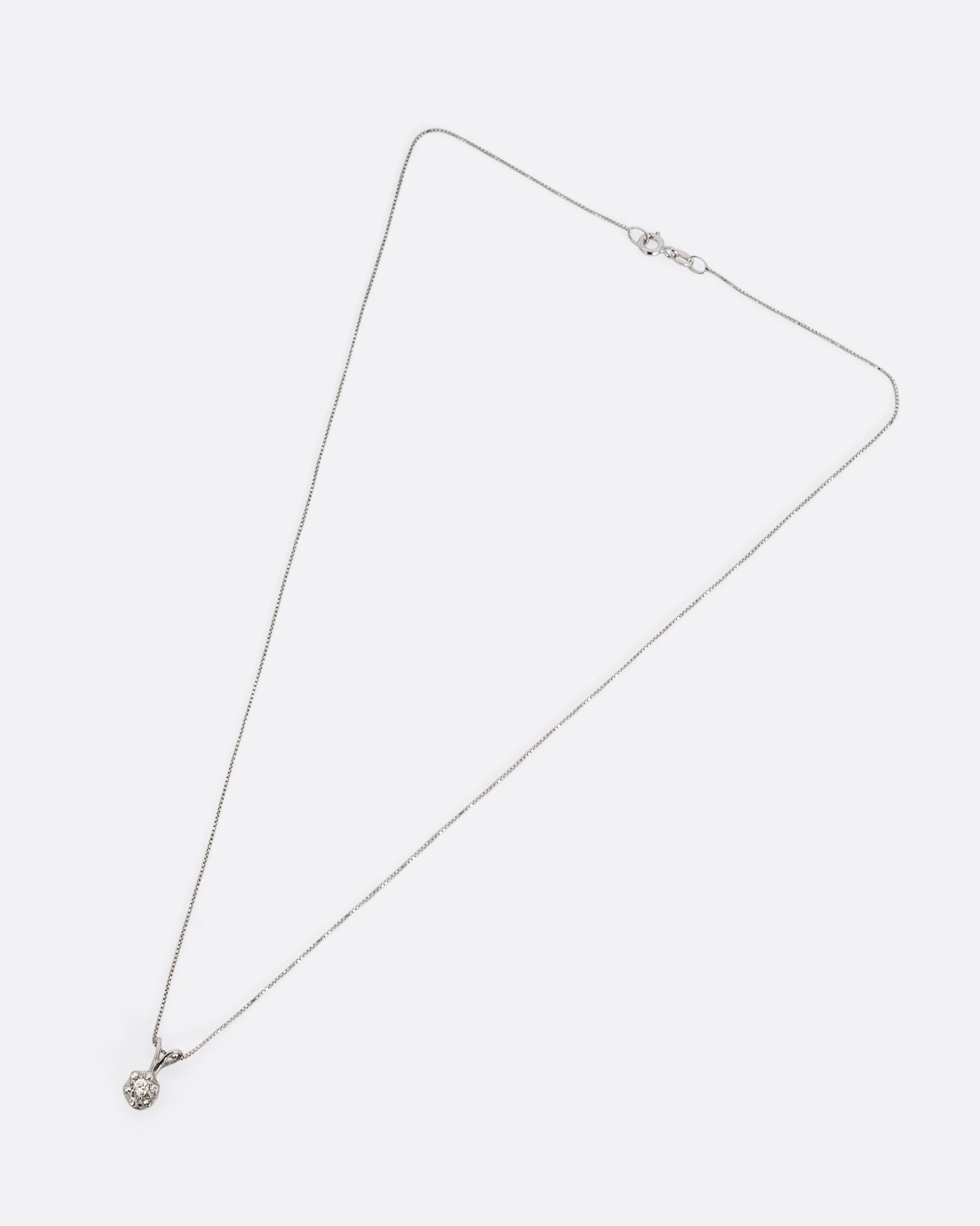 A white gold box chain necklace with a diamond studded flower shaped pendant. Shown from the front.