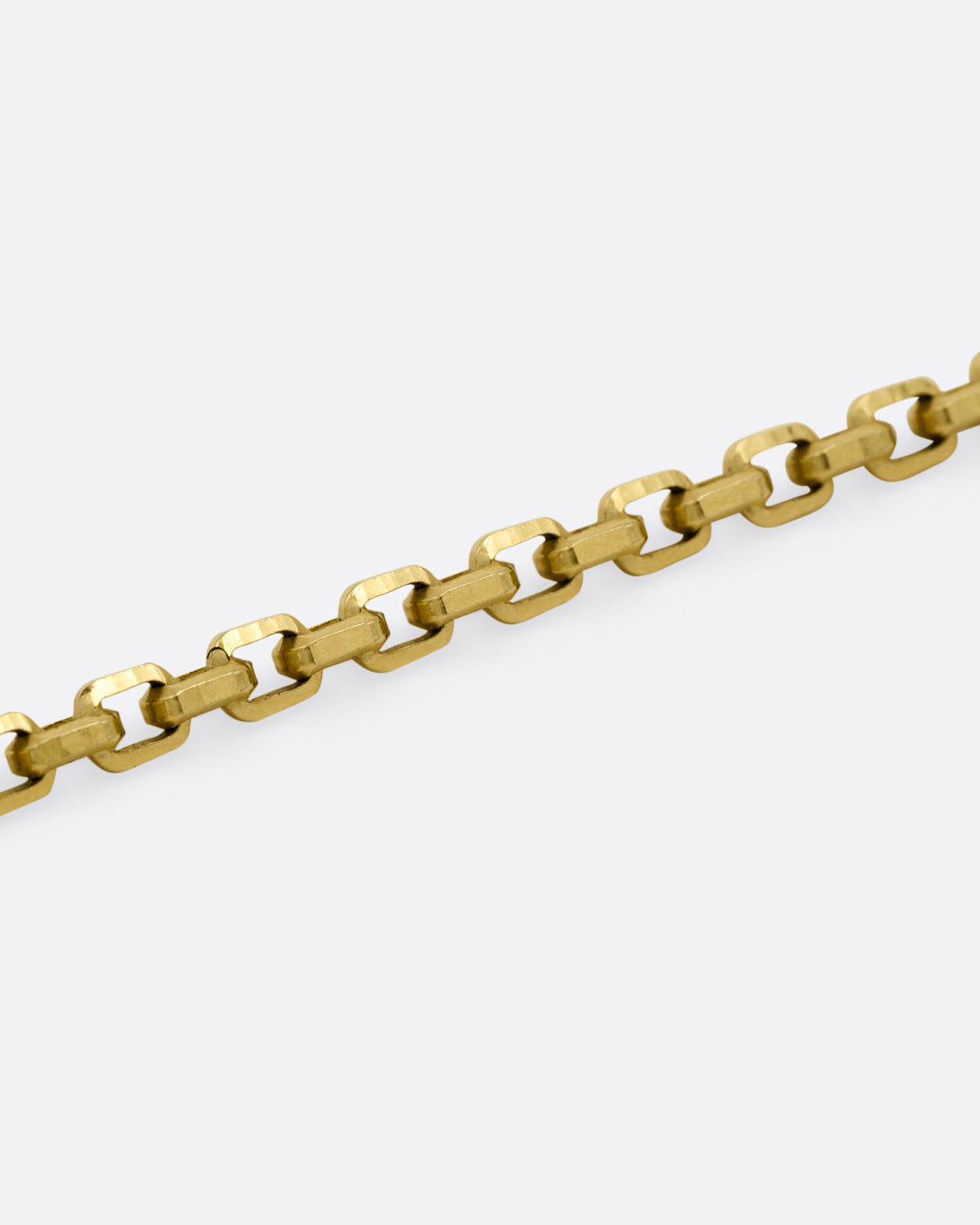 A close up of a yellow gold square link necklace.