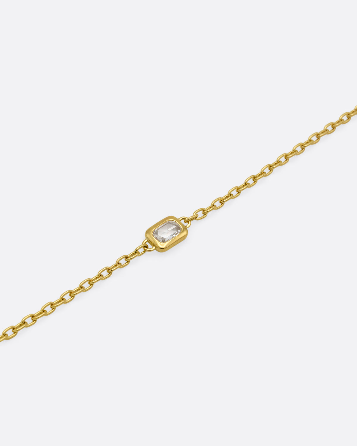 A yellow gold cable chain bracelet with a  rectangular rose cut diamond, shown from the front.