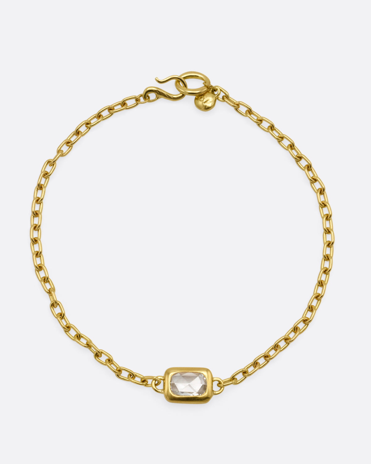 A yellow gold cable chain bracelet with a  rectangular rose cut diamond, shown from the front.