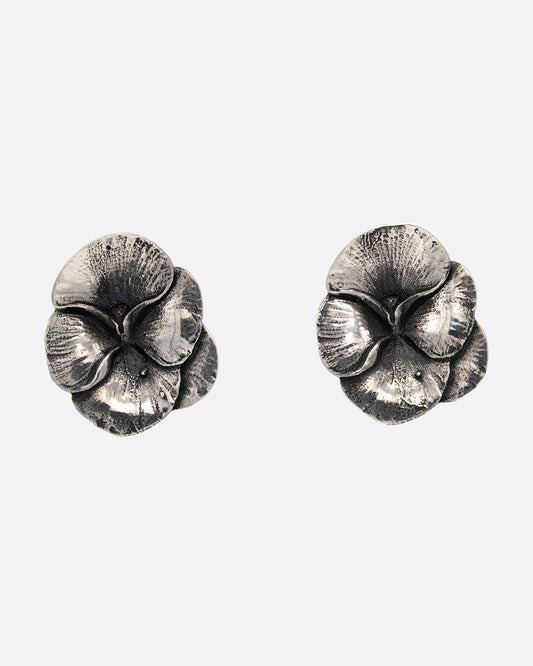 A pair of silver pansy earrings, shown from the front.