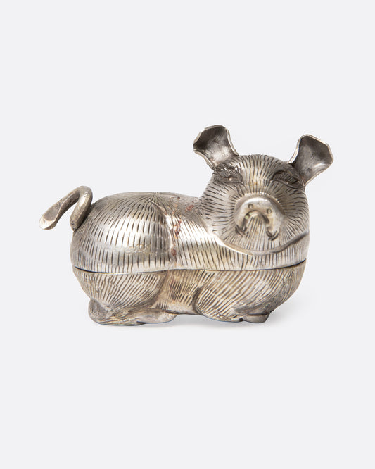 A silver pig betel box shown from the front.