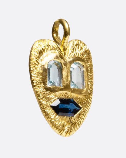 Yellow gold heart face pendant with aquamarine and sapphire, angled view of the heart showing the hand-carved texture