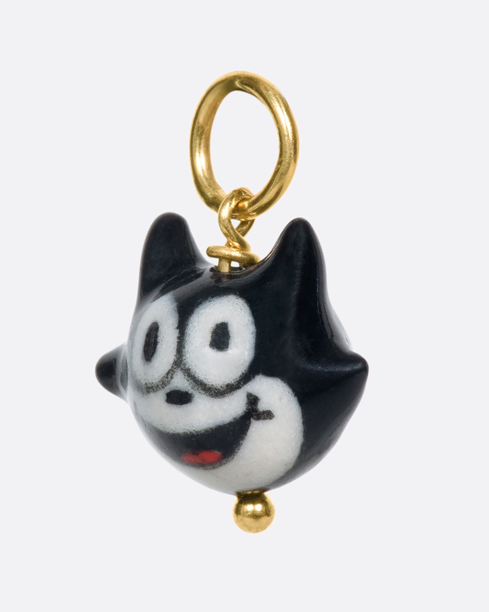 A handmade and painted porcelain Felix the Cat charm with a 14k gold bail