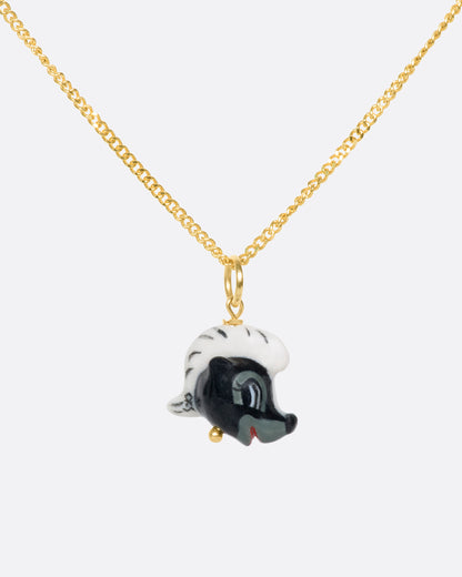 Porcelain skunk head charm worn on a gold chain