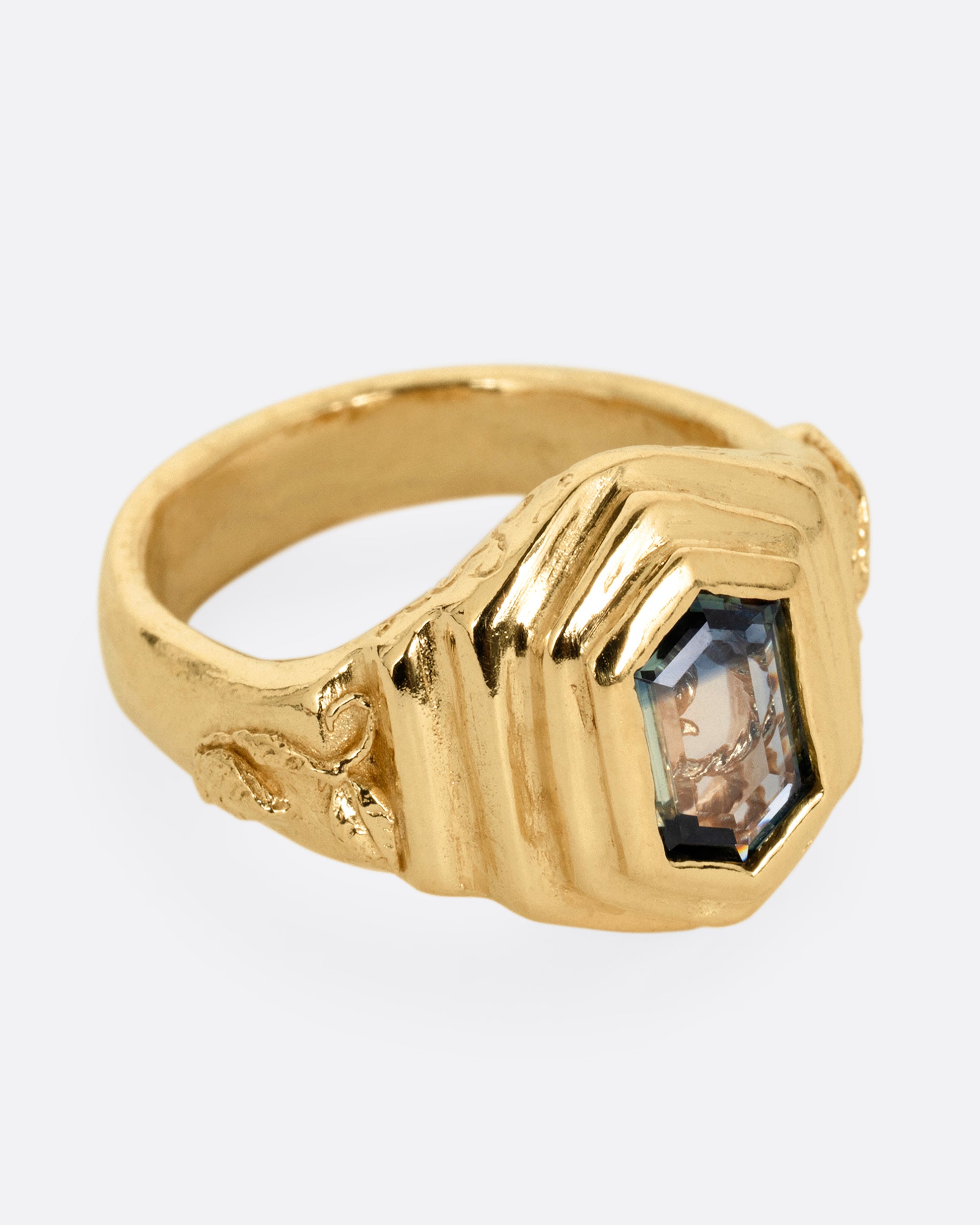 A yellow gold with a stepped center and a portrait cut bicolor tourmaline with a gold tendril that reveals itself through the stone. Shown from the side.