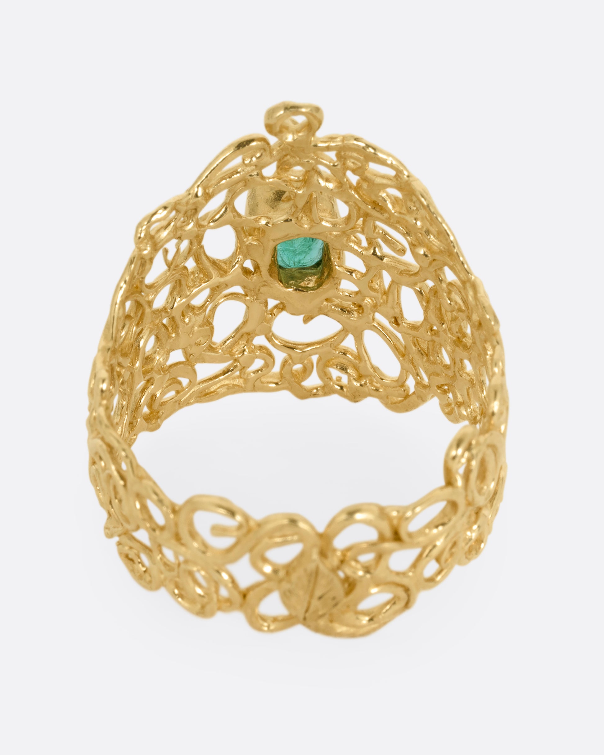 A wide yellow gold curling vine ring with  a central emerald. Shown from the back.
