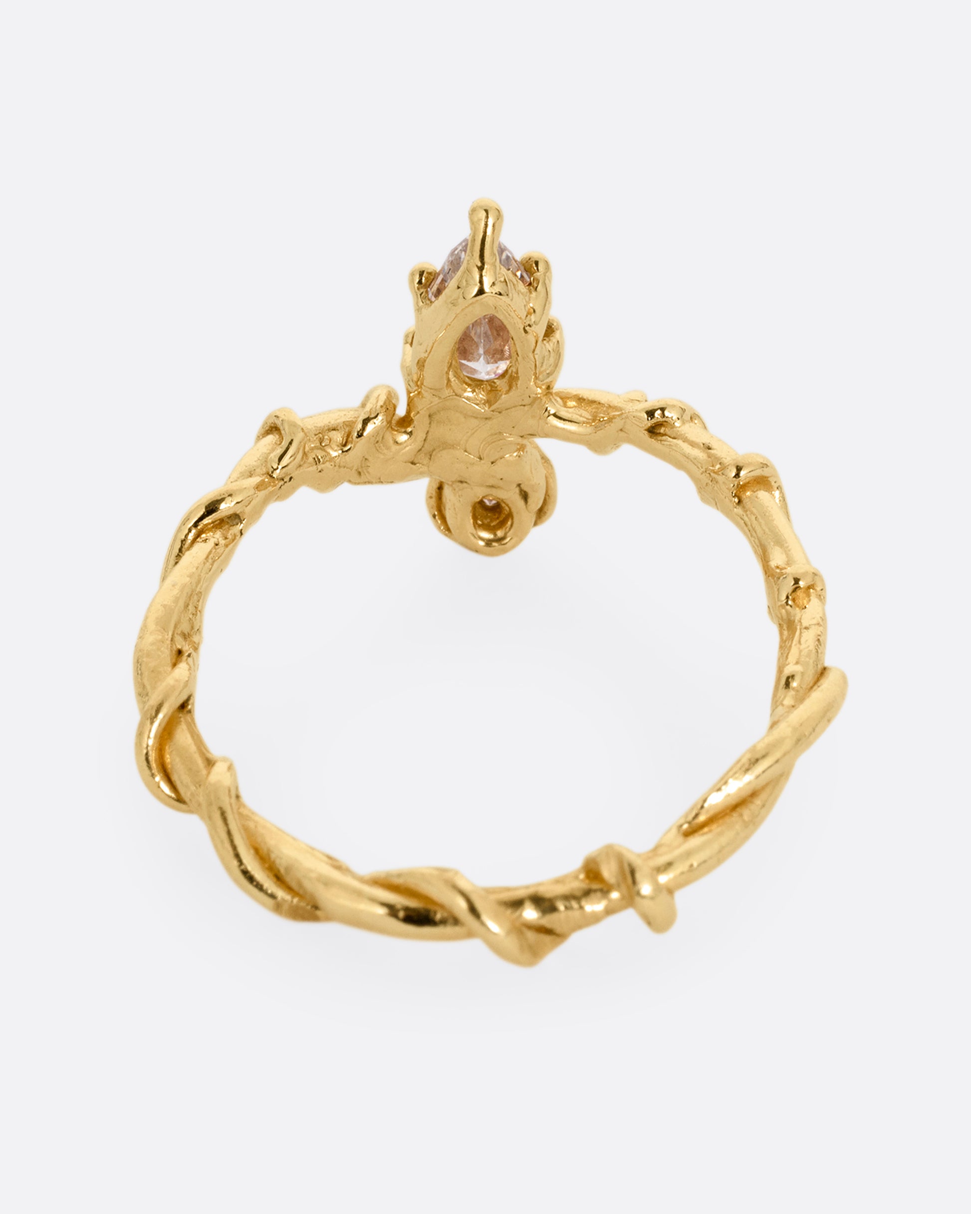 A yellow gold ring with a vine wrapped band and two stacked diamonds, one pear one round. Shown from the back.
