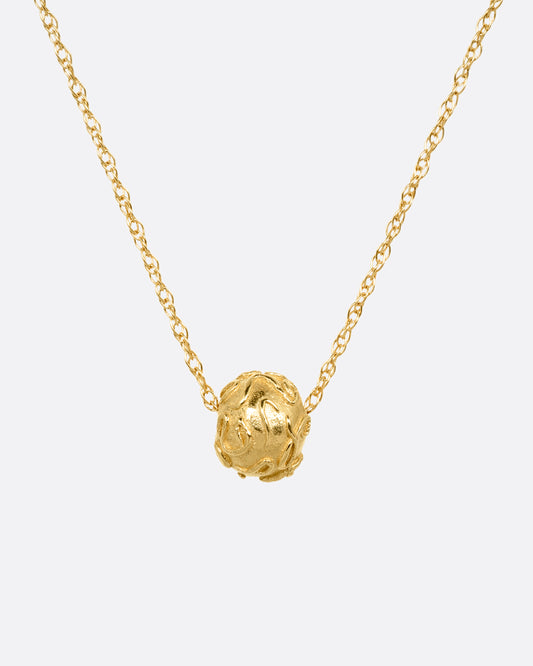 A yellow gold cable chain with a textured gold bead, shown from the front.