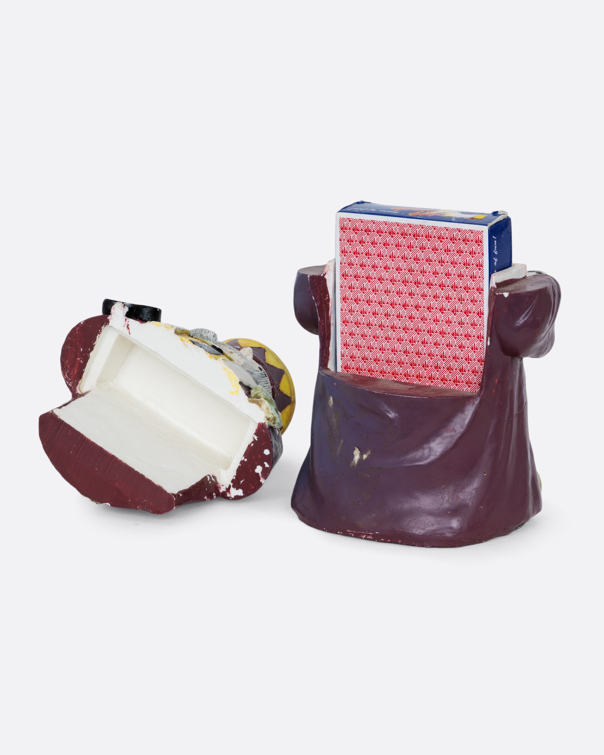 A card holder king of clubs figurine with a purple robe and crown, shown from the back open with playing cards inside.