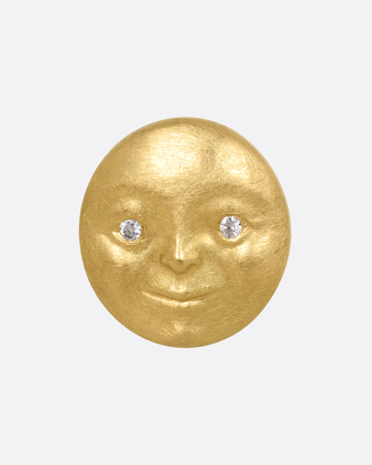 A yellow gold moon face stud earring with diamond eyes. Shown from the front.