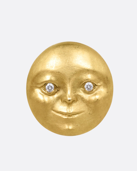 A yellow gold moon face stud earring with diamond eyes. Shown from the front.