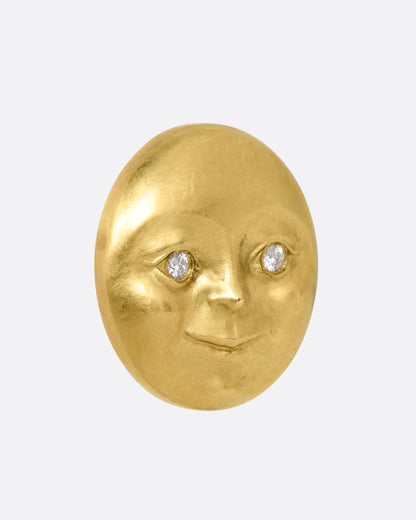 A yellow gold moon face stud earring with diamond eyes. Shown from the side.