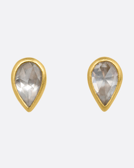 A pair of yellow gold tear drop shaped stud earrings with diamonds. Shown from the front.