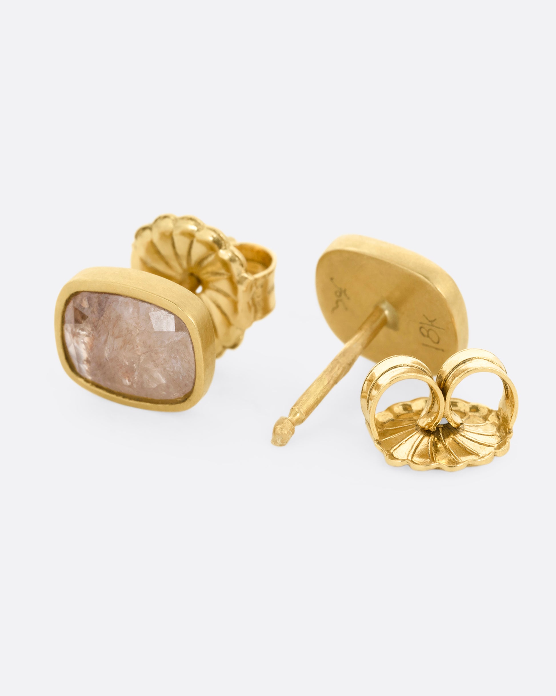 A pair of yellow gold rectangular salt and pepper stud earrings. One earring is shown from the front, the other is shown open from the back.