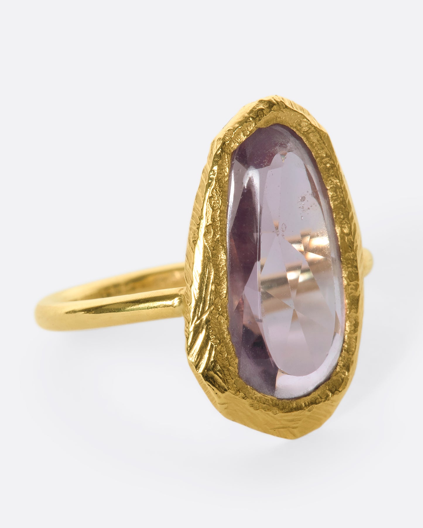 This truly unique freeform, rose-cut purple sapphire is nestled in a hand-carved 18k gold bezel setting