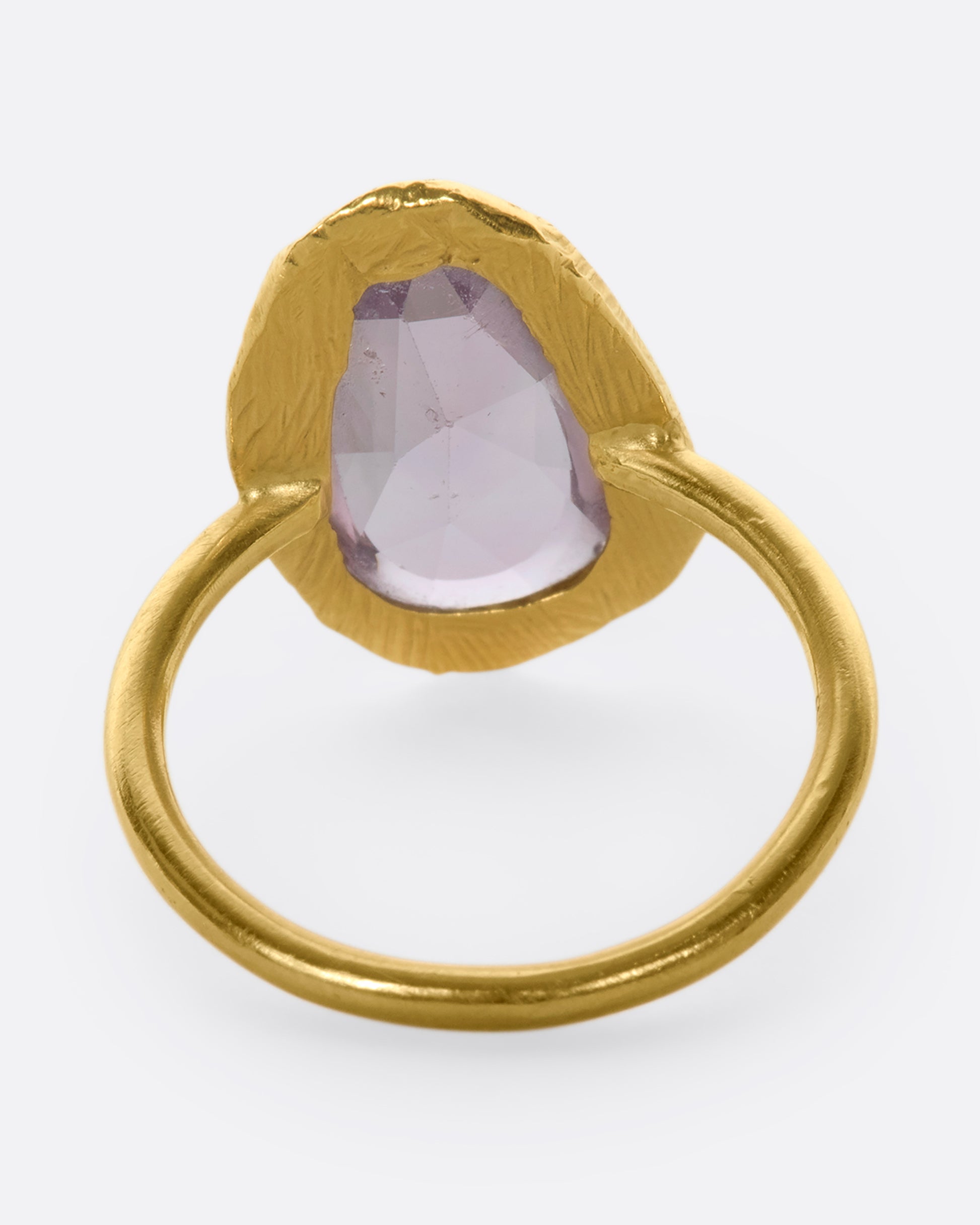 This truly unique freeform, rose-cut purple sapphire is nestled in a hand-carved 18k gold bezel setting