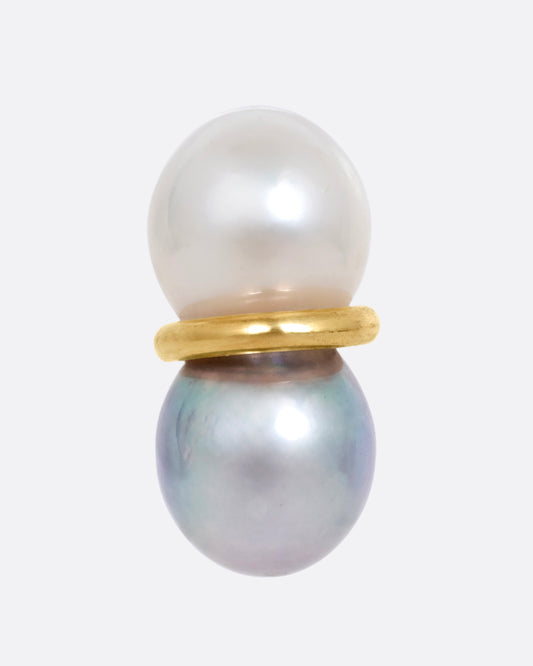 A pearl earring with a gold loop around the middle, shown from the front.