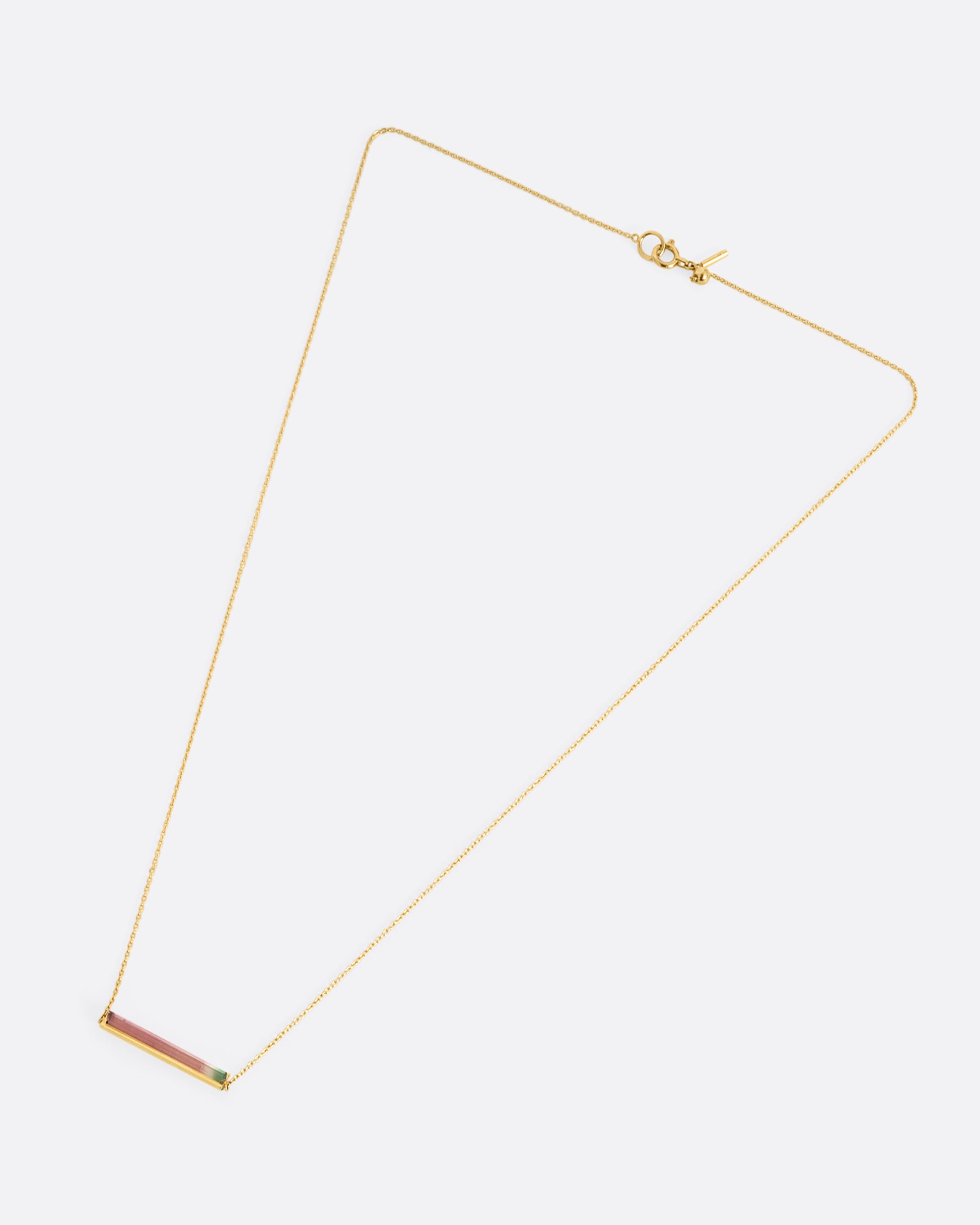 A yellow gold cable chain necklace with a watermelon tourmaline and gold bar, shown from the front.