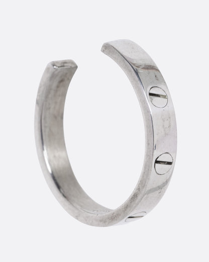 A silver hoop earrings with a motif mimicking flat head screws, shown from the side.