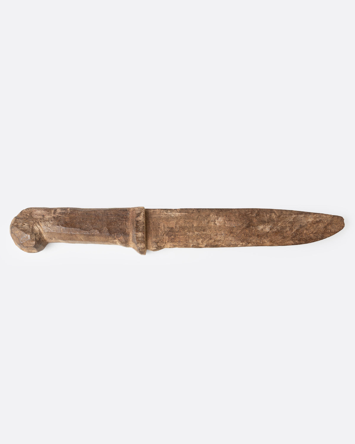A hand carved wooden knife, shown from the side.