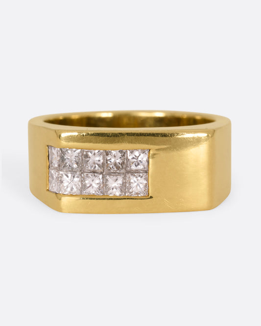 A yellow gold rectangular signet ring with 10 princess cut diamonds on one corner, shown from the front.