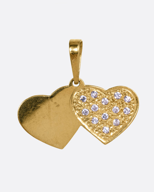 A yellow gold double heart charm with pavé diamonds over a stipple finish on one heart. Shown from the front.