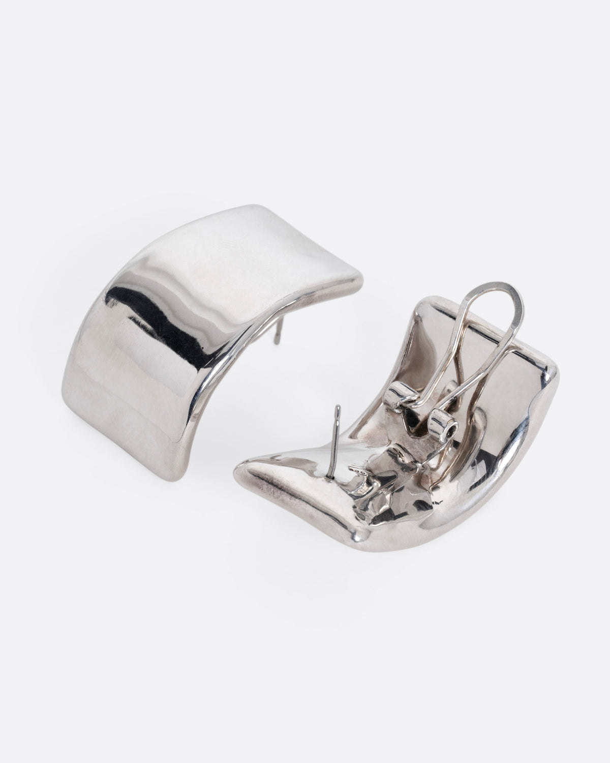 A pair of silver rectangular curved earrings. One earring is shown from the front, the other from the back open.