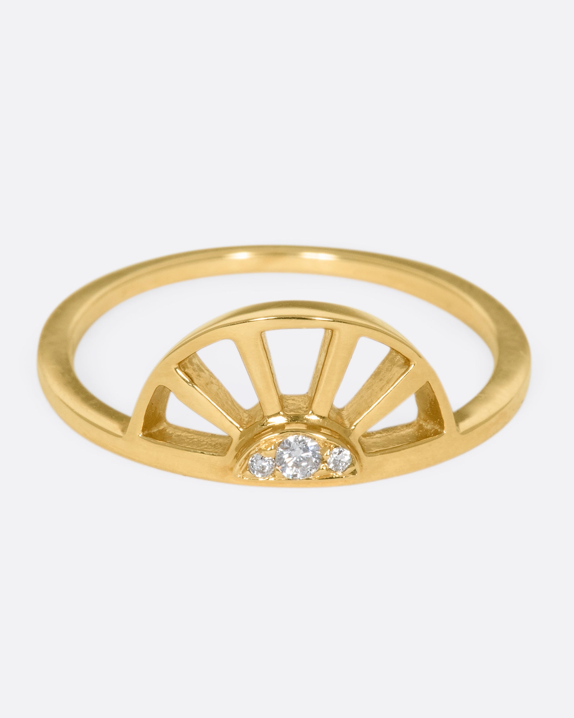 A yellow gold ring with a sun at the center and three white diamonds. Shown from the front.