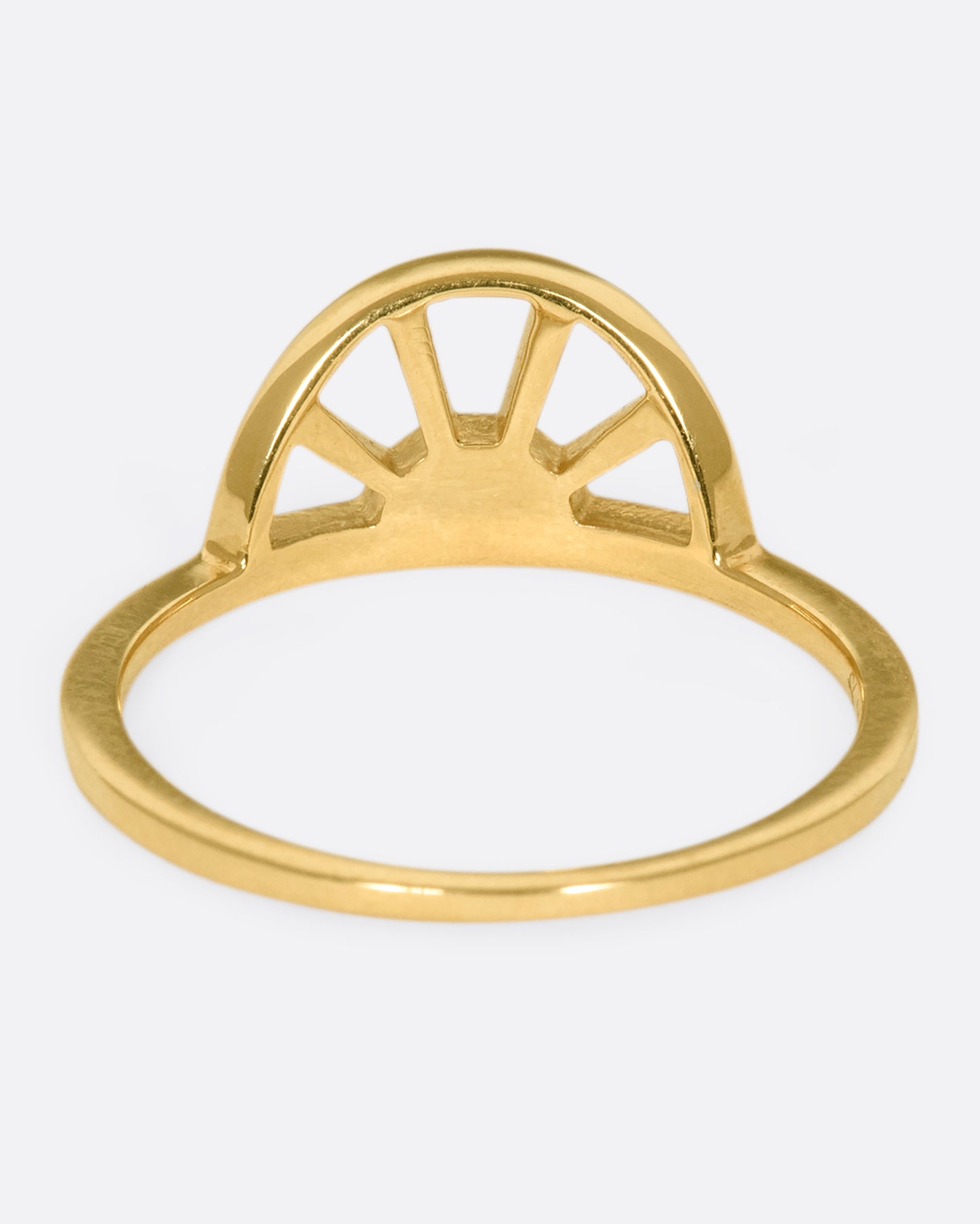 A yellow gold ring with a sun at the center and three white diamonds. Shown from the back.