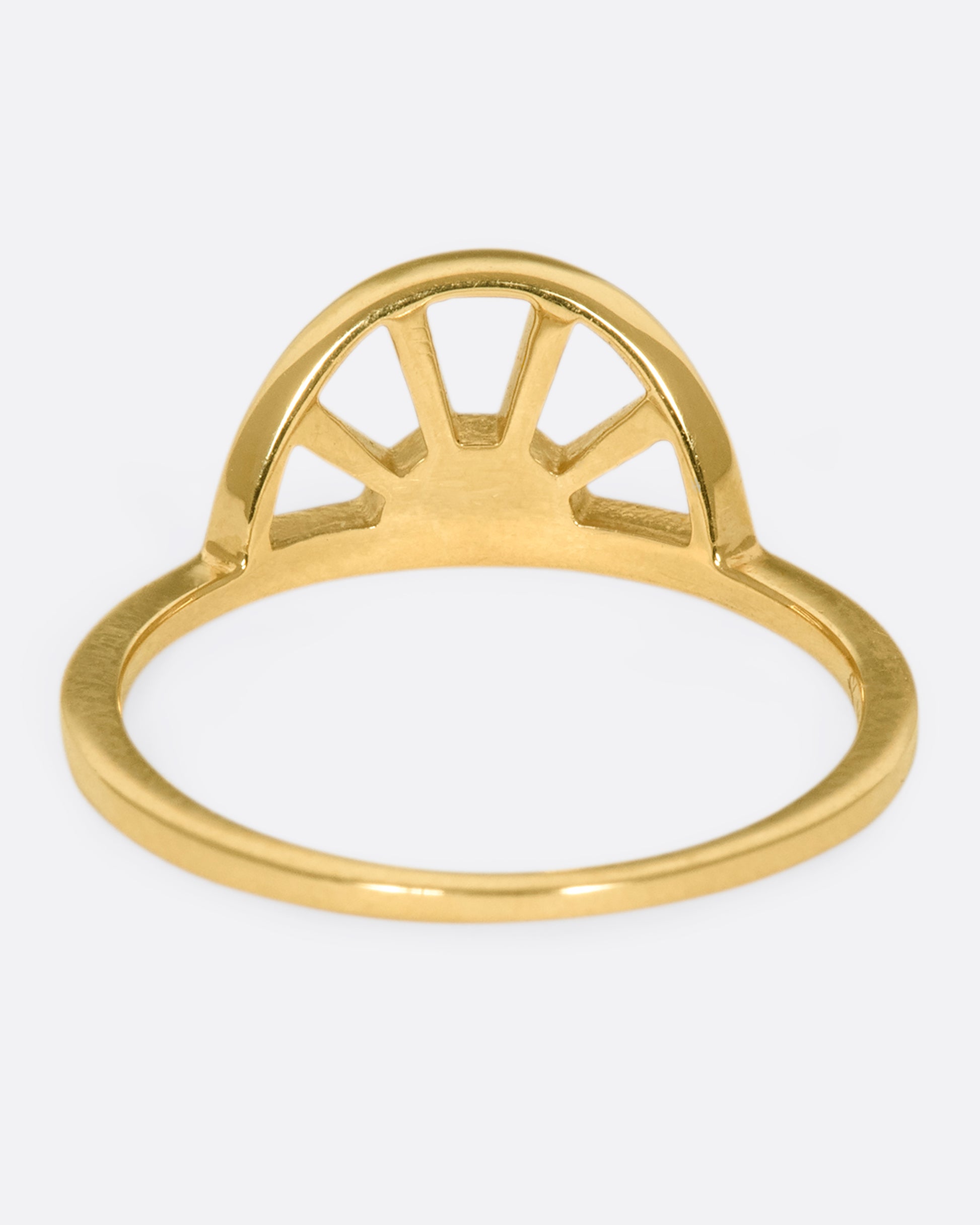 A yellow gold ring with a sun at the center and three white diamonds. Shown from the back.