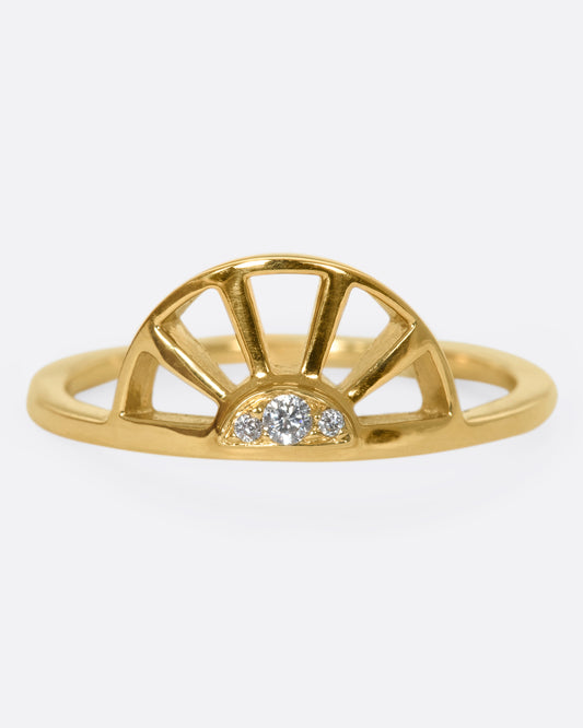 A yellow gold ring with a sun at the center and three white diamonds. Shown from the front.