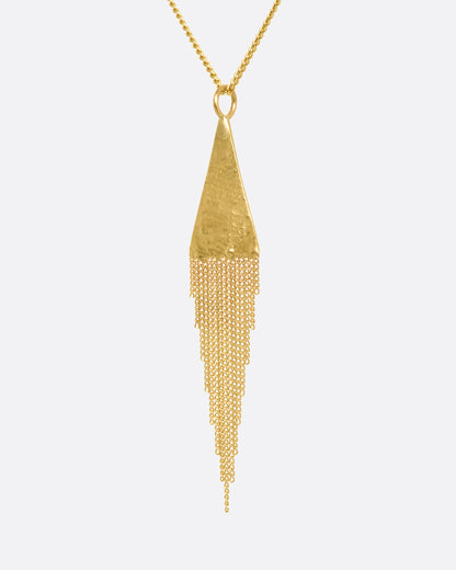 A yellow gold necklace with a fringed triangle pendant. View up close from the side.
