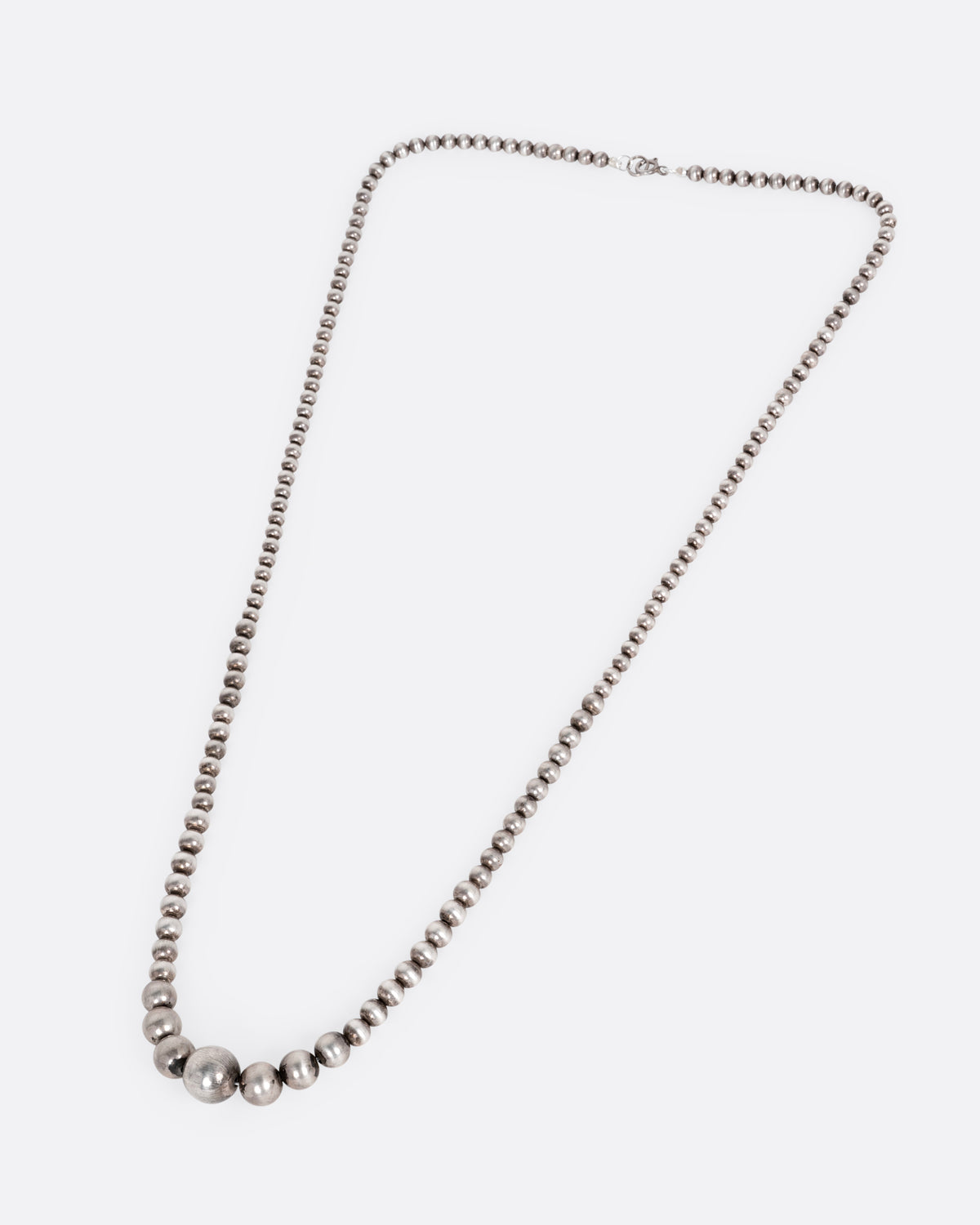 A silver beaded necklace, shown from the front.