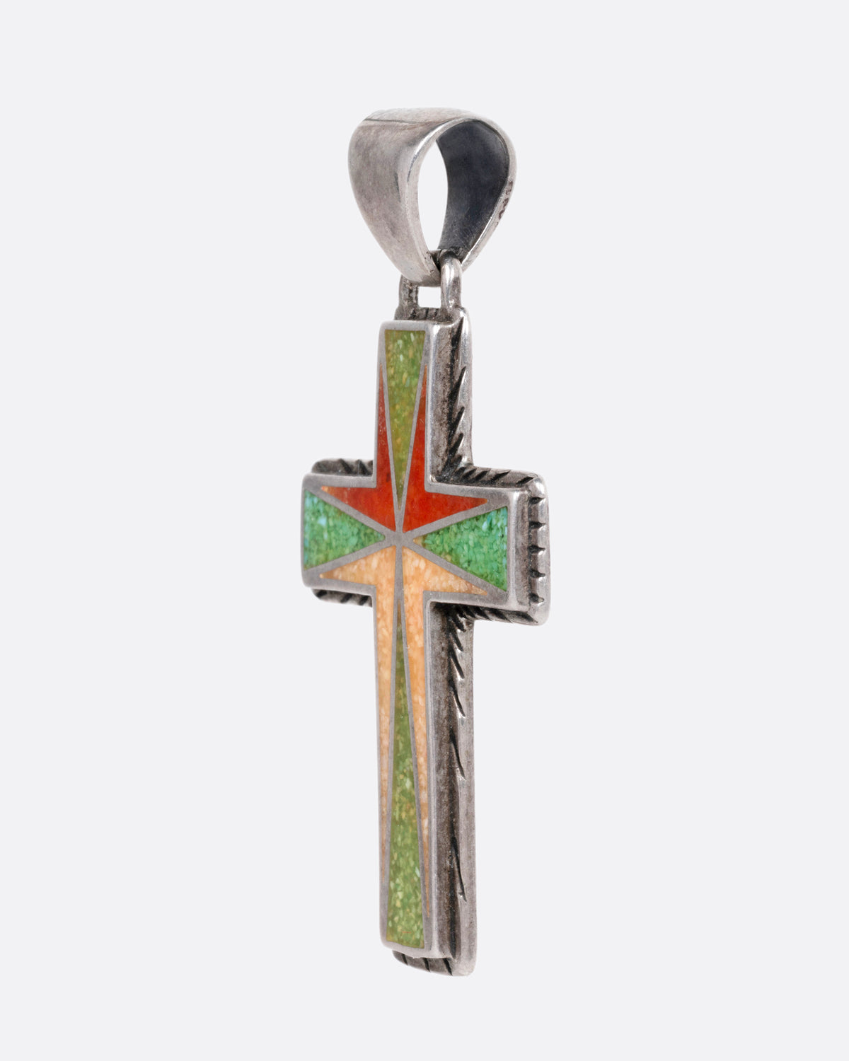 A silver cross with colorful inlay, shown from the side.