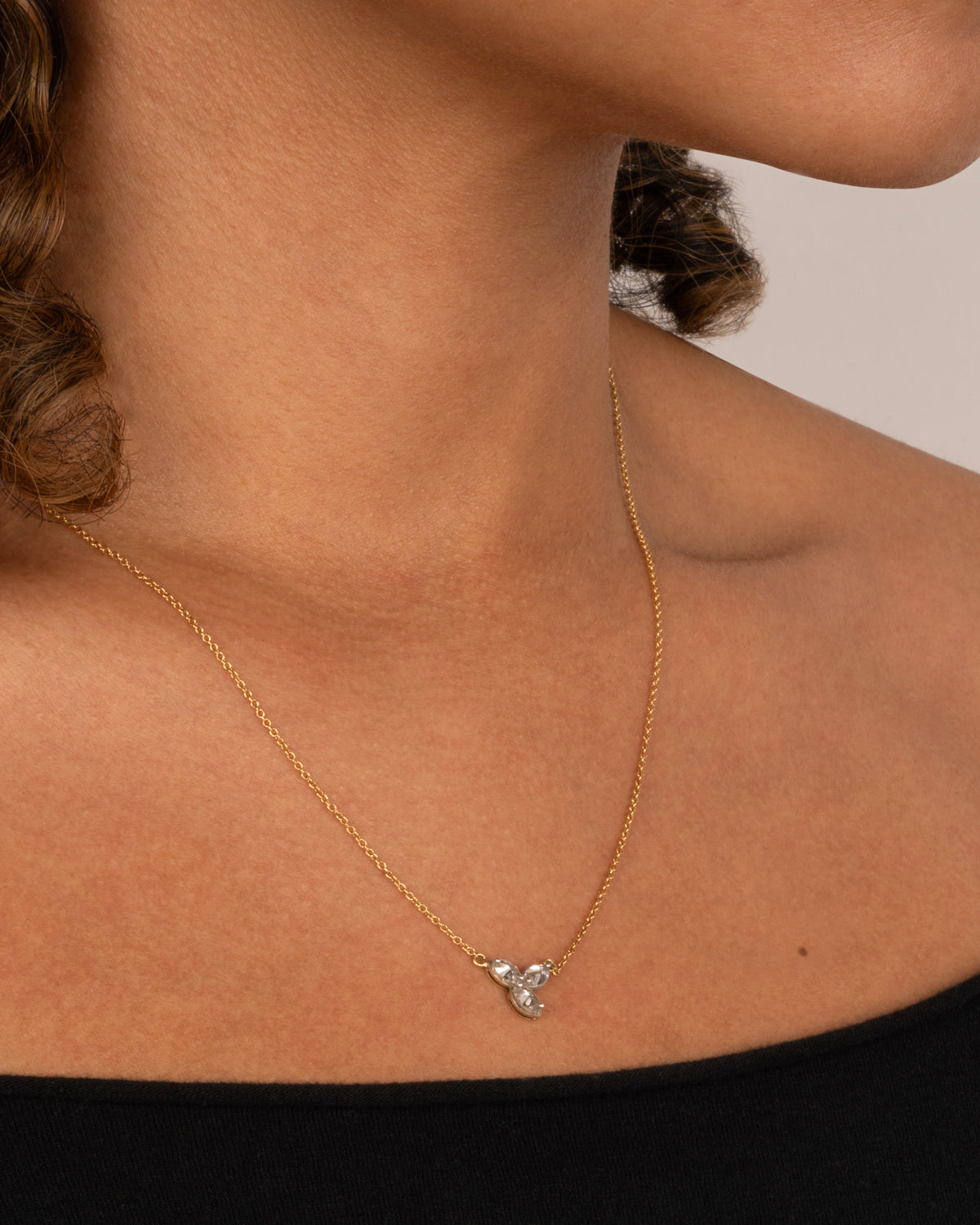 White and yellow gold marquise diamond trefoil necklace worn at the collarbone