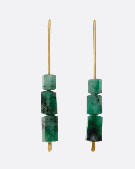 A pair of yellow gold hook earrings with three stacked freeform emeralds. Shown from the front.  