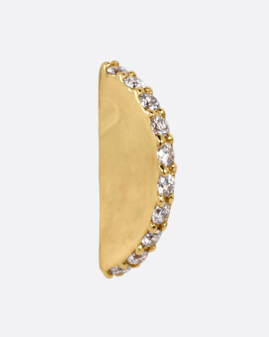 A half moon yellow gold stud with a diamond studded edge, shown from the side.