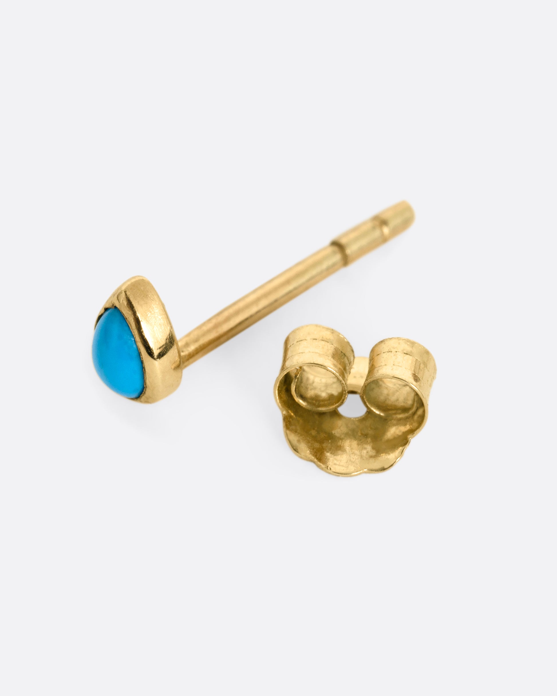 A yellow gold stud earring with a pear shaped bezel set turquoise. Shown open from the side.