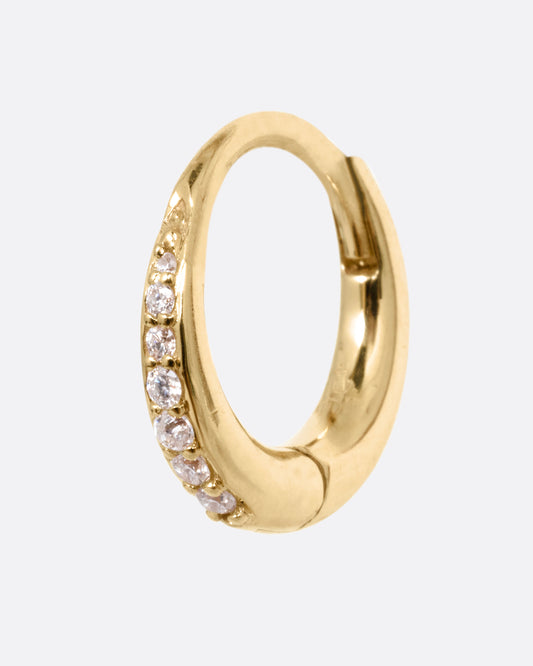 A yellow gold tapered hoop earring with a queue of graduated diamonds, shown from the side.