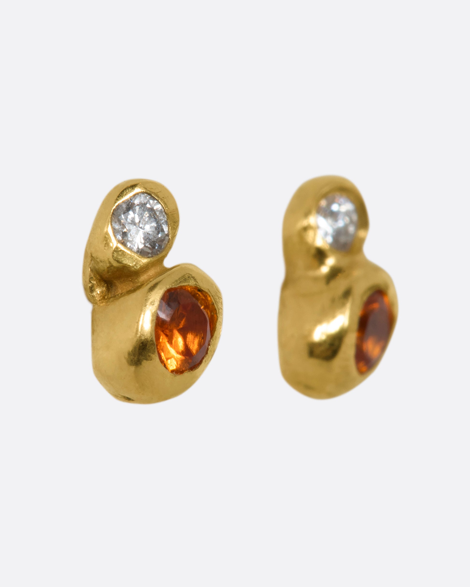 A pair of yellow gold bubble studs with orange sapphires and diamonds. Shown from the side.