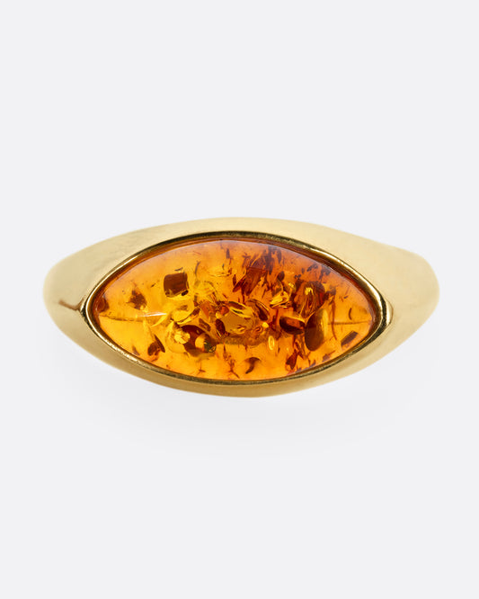 A yellow gold ring with an oval amber, shown from the front.