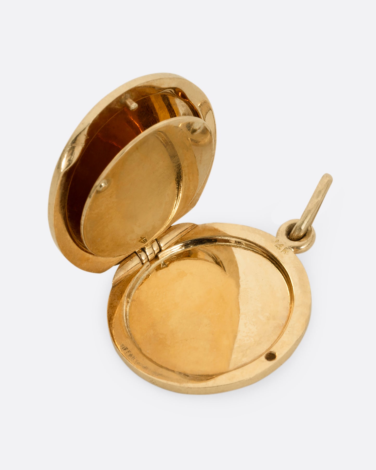 A yellow gold St. Christopher, medallion locket with 'Look at me and be safe' engraved on its edge with a photo frame and a secret slot for a memento on its interior. Shown open.