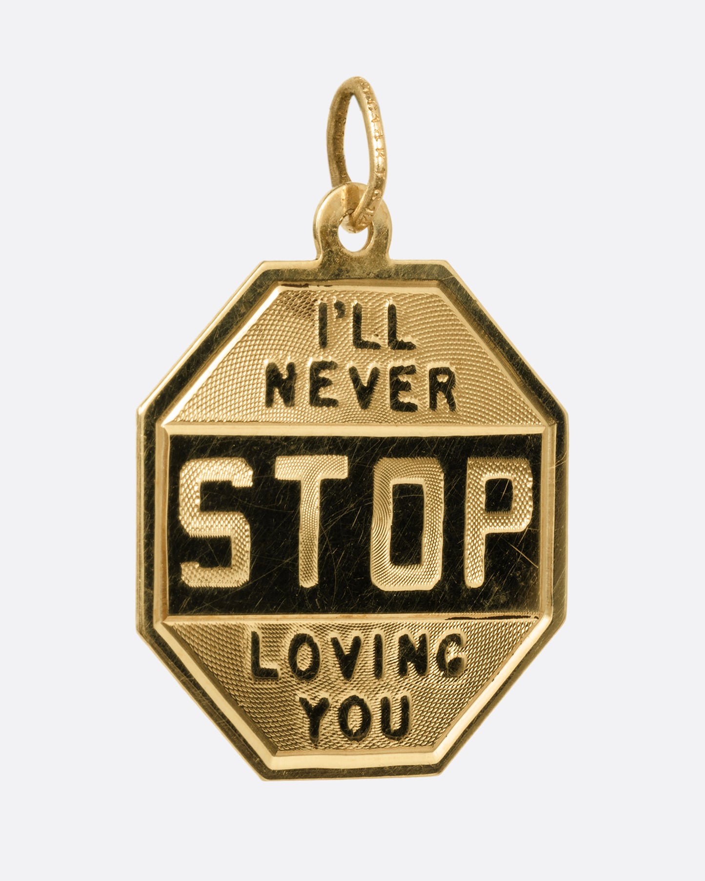 A yellow gold stop sign pendant with 'I'll Never STOP Loving You' on its front and 'Happy Birthday 1964' engraved on its back. Shown from the front.