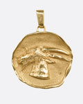 A yellow gold freeform medallion with a goat portrait at the center, shown from the front.