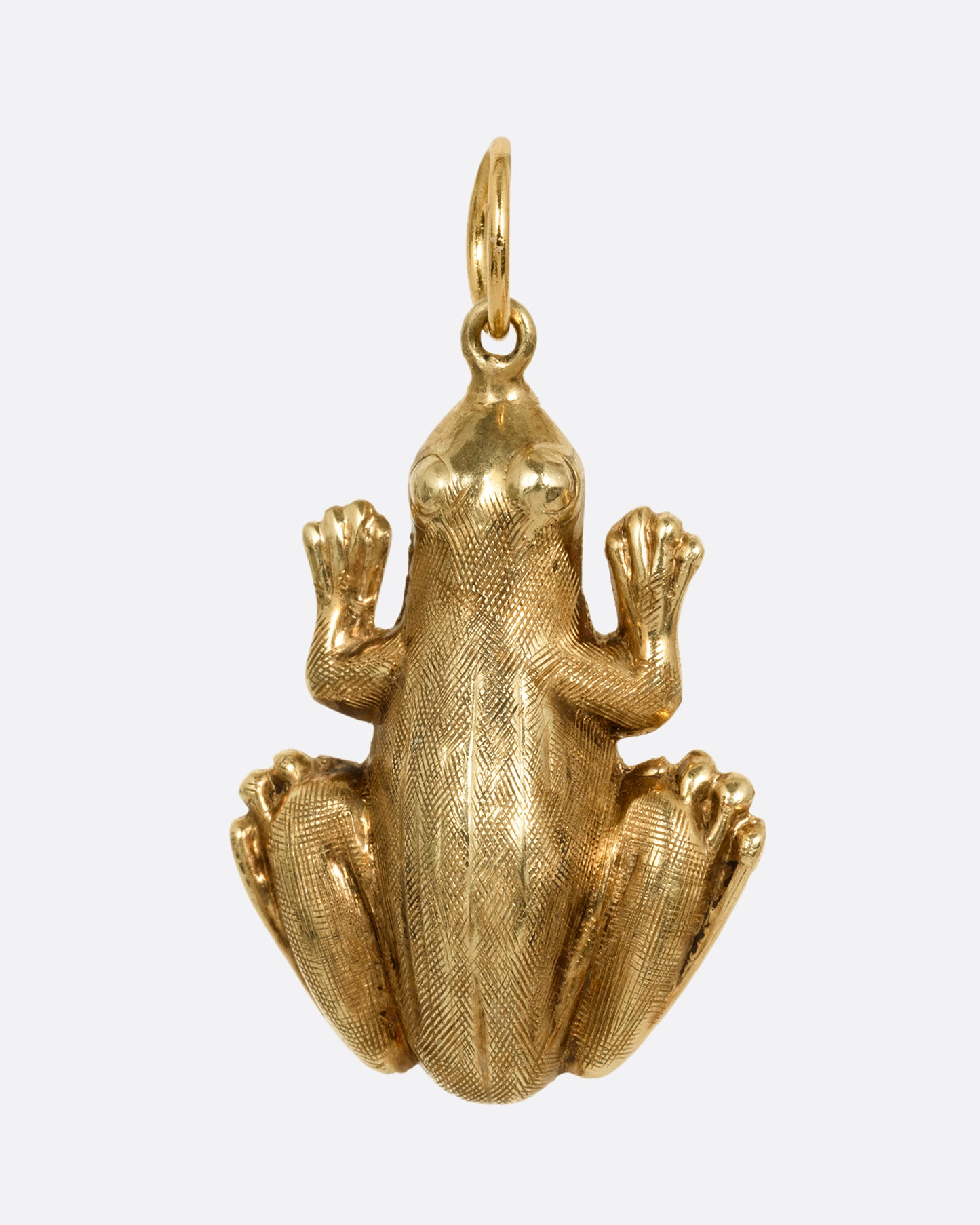 A yellow gold frog pendant shown from the front.