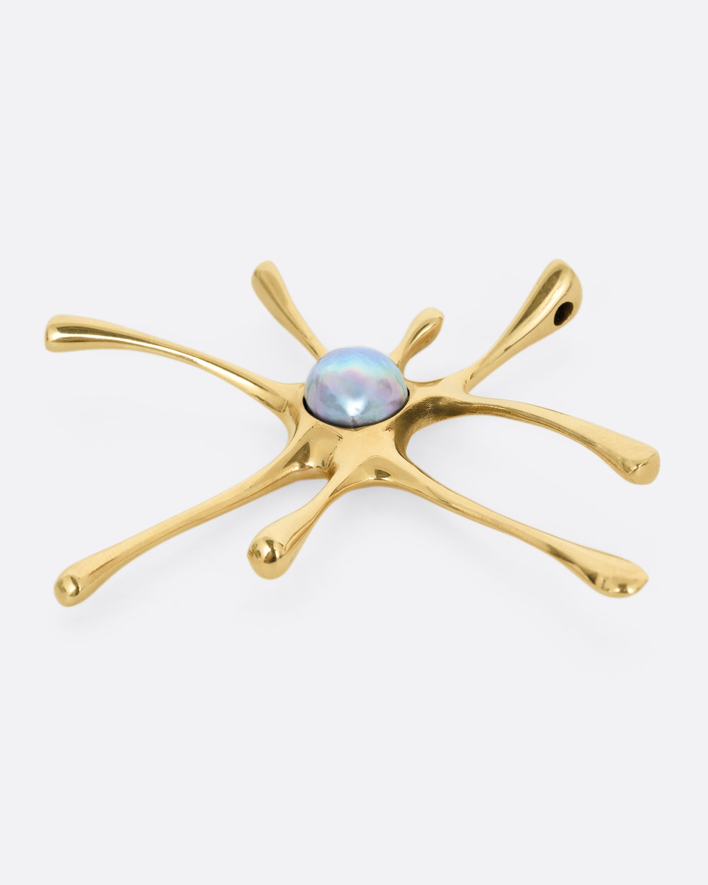 A yellow gold amoeba shaped pendant with a central pearl, shown lying flat from the side.