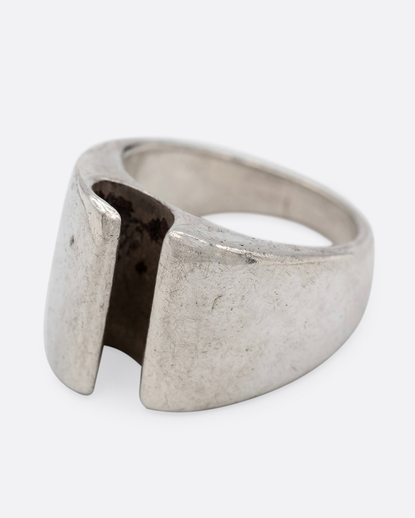 A silver ring with a notch in the front, shown from the side.